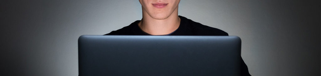 Jeune adulte utilisant son ordinateur portable qui a aussi un effet sur la santé des yeux.